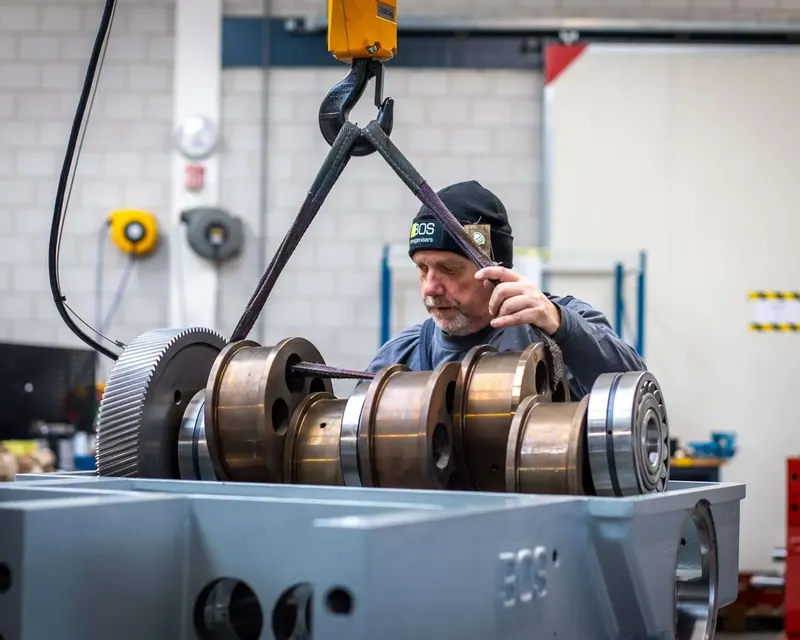 BOS Homogenisers technician assembling crankshaft and drive gear into homogeniser housing in the workshop