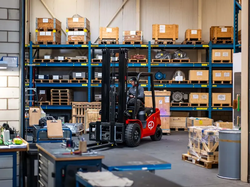 BOS spare parts warehouse in Hilversum with forklift and stocked racks